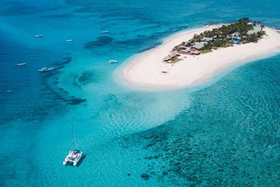 aerial-image-of-namotu-island-surrounded-by-boats-and-reef-with-beautiful-water-banner