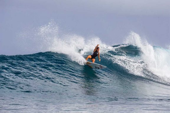 girl-surfing-wave-near-namotu-island-fiji