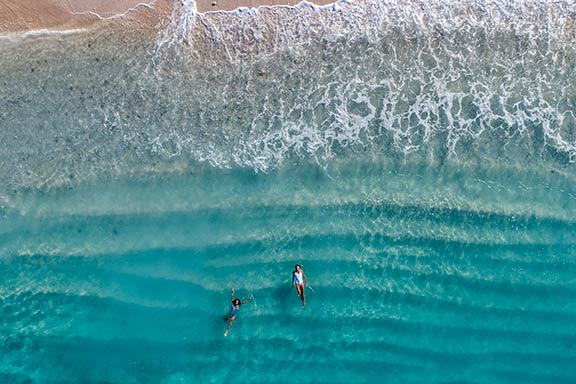 overhead-view-of-women-swimming-in-aqua-blue-water-at-namotu-island-fiji