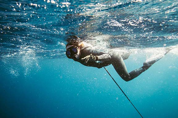 woman-diving-in-blue-water-off-namotu-island-fiji